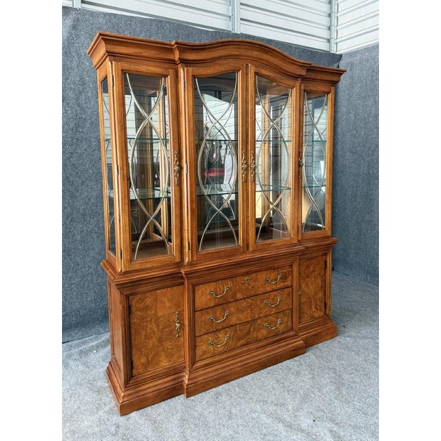 This Thomasville burled walnut china cabinet showcases beautifully figured wood with rich, swirling grain, complemented by...