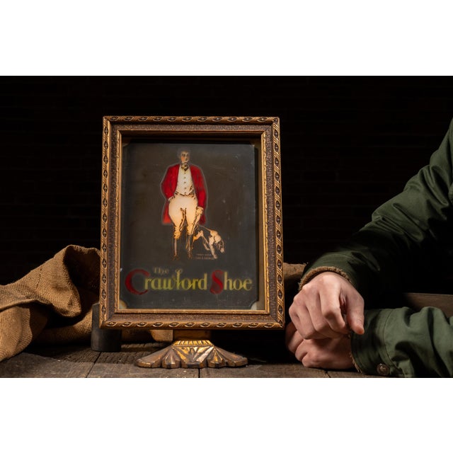 Illuminated countertop advertising sign for The Crawford Shoe, featuring the brand's iconic gentleman-and-dog graphic...
