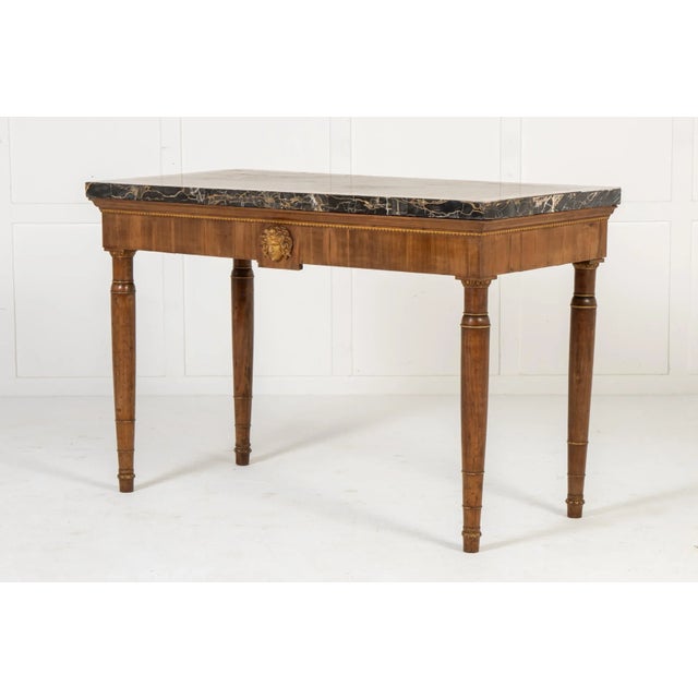 An Early 19th Century Italian Walnut Console Table with Marble Top. This fine Italian console or side table stands on four...