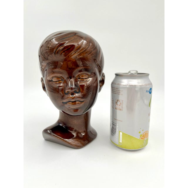 This bust of a young boy is covered in a rich brown glaze with beautiful color variations which are hard to capture in...