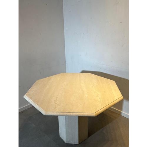 Elegant vintage dining table crafted in beautiful natural travertine stone. The table features a striking octagonal top...