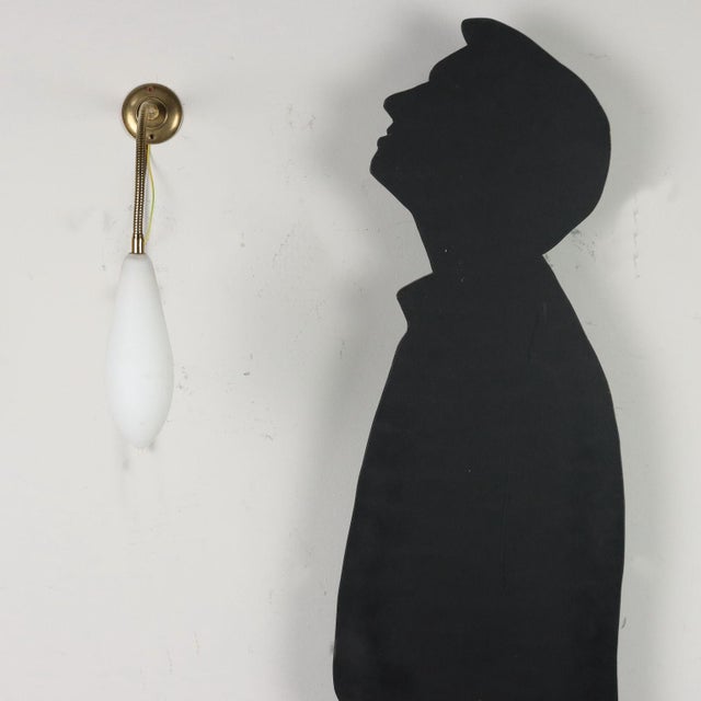 Wall lamp with flexible stem. Brass, opal glass. This piece is attributed to the mentioned designer/maker. It has no...