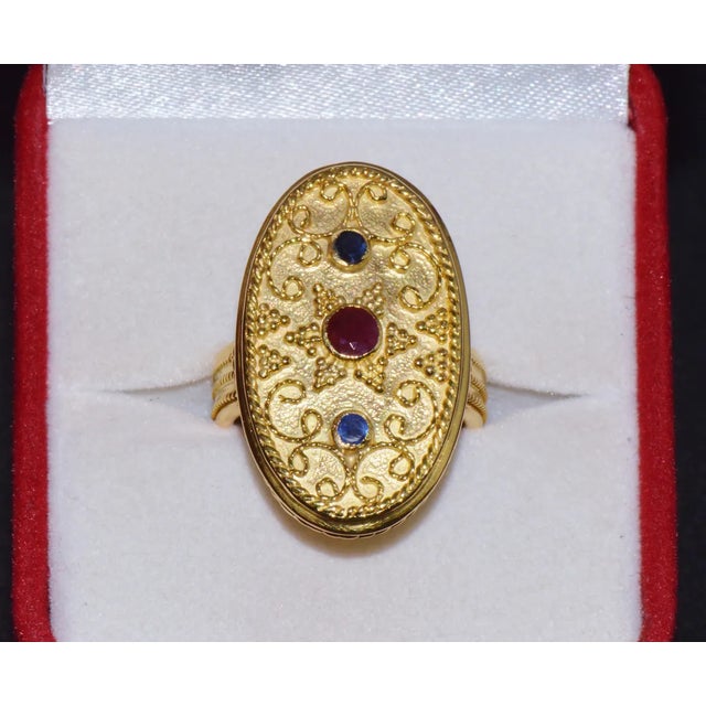 Gorgeous natural 18K solid gold ruby and blue sapphire Greek ring. This finely crafted 18k solid gold ring features...