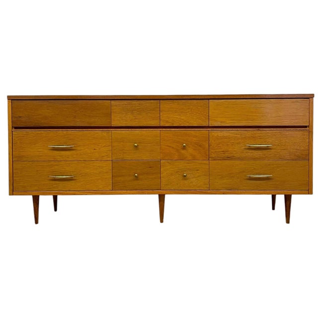 Vintage mid century modern long low dresser featuring a clean, linear silhouette and a warm wood tone. The piece offers a...