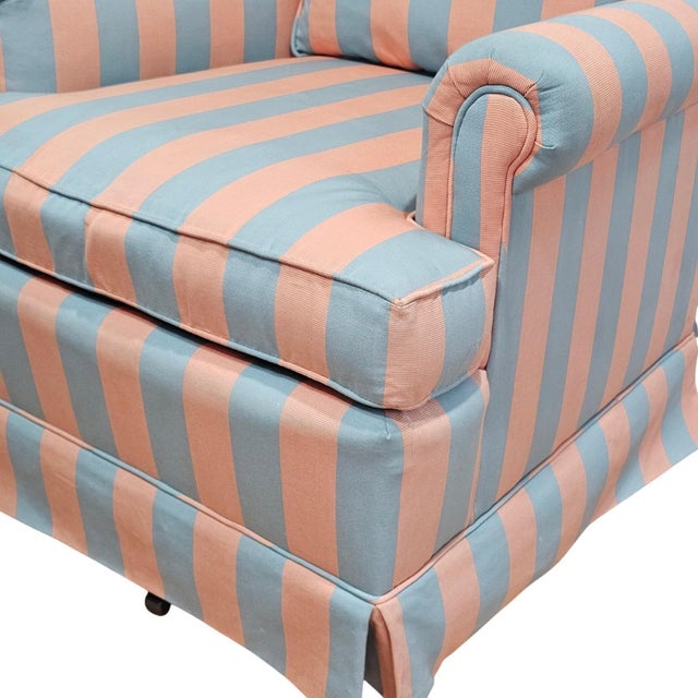 Lee Industries upholstered swivel rocker armchair showcases a timeless vertical stripe pattern in a soft coral and dusty...