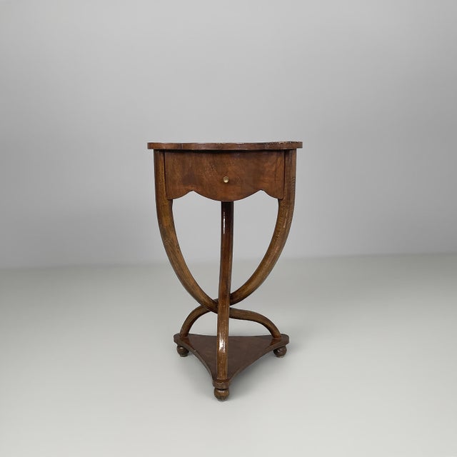 French art deco wooden bedside tables, 1930s Pair of dark wood bedside tables featuring shaped tops, a front drawer fitted...