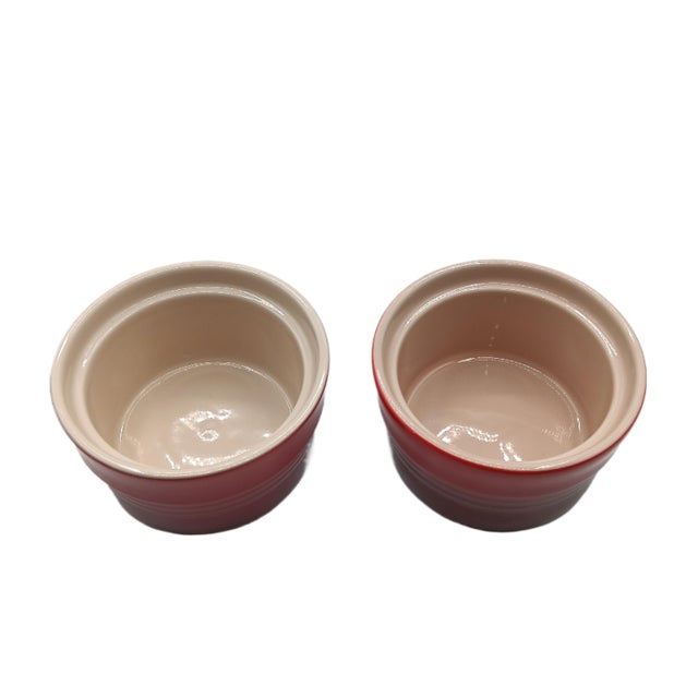 Brand: Le Creuset Color: Cerise/Red Material: Stoneware Exterior dimensions: 3.7" L, 3.7" W, 2.2" H Includes 2 stoneware...