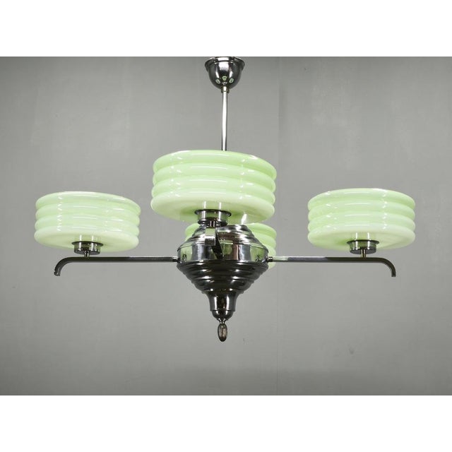 Original Art Deco chandelier produced in Czechoslovakia during the 1930s. Featuring four beautifully preserved light green...