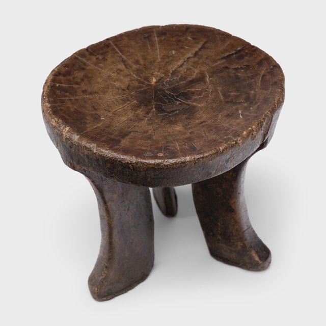 Hand-carved from a single, solid block of wood, this antique African stool has a unique personality and abstract form - as...