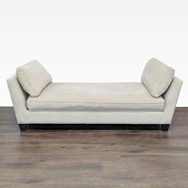 This Crate & Barrel chaise lounge sofa features a clean, modern design with a soft beige fabric. It has plush, removable...