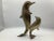 A cute mama and baby brass dolphin statue. The baby dolphin is staring at the mama dolphin. The brass dolphins are in...