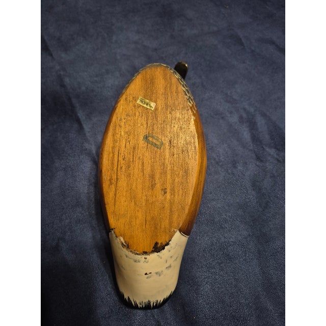 The object is a hand-carved wood decoy depicting a Canada goose (Branta canadensis), characterized by its distinctive...