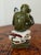 A wonderfully expressive ceramic monkey figurine holding a small mirror, full of the humor and personality that make...