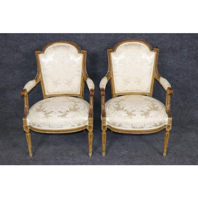This elegant pair of early 1920s French Louis XVI fauteuil armchairs embodies the refined craftsmanship and timeless...