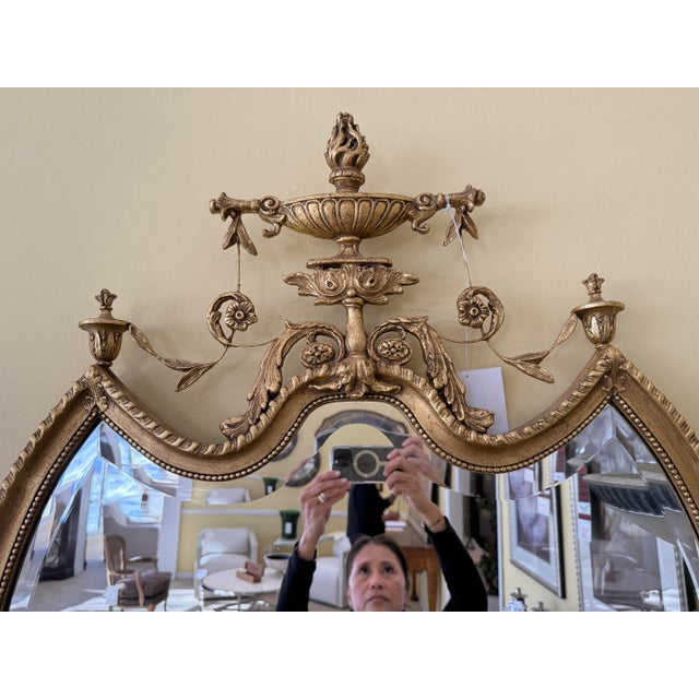 An elegant study in neoclassical glamour, this giltwood shield mirror brings sculptural presence to any room. The shield-...