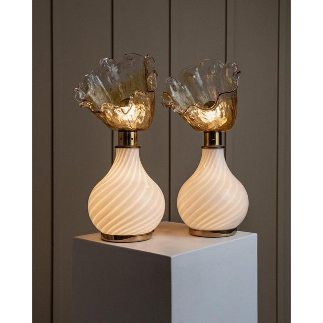 This pair of vintage Murano glass table lamps from the 1970s showcases a unique design, featuring flower-shaped glass...