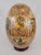 Extra large Satsuma egg is hand painted with larger scenes of Geisha on the front and back and smaller floral and nature...