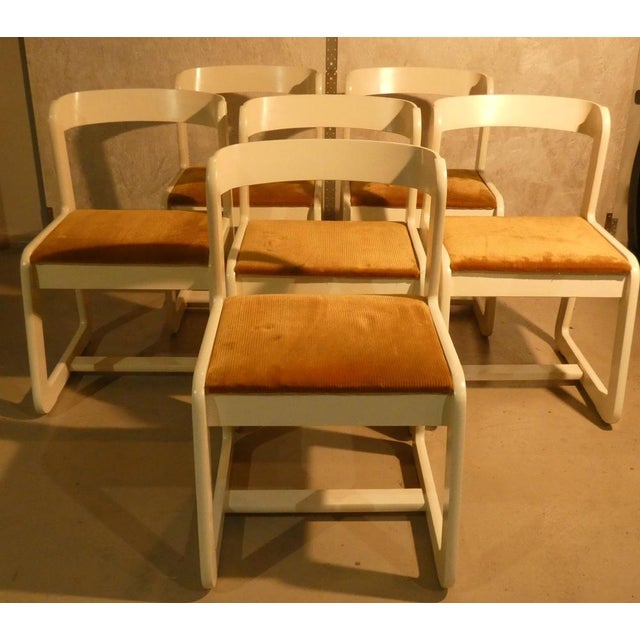 The chairs designed by mario sabot, here proposed in white wood, with a mustard seat with a mustard -colored coast seat....