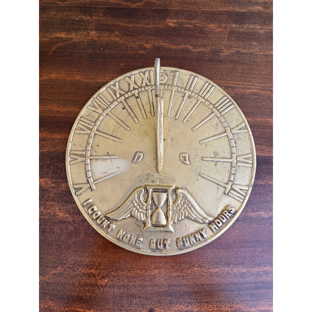 A stunning vintage brass garden sundial reading "I count none bust sunny hours." USA, Late 20th Century Measures: 8.13"W x...