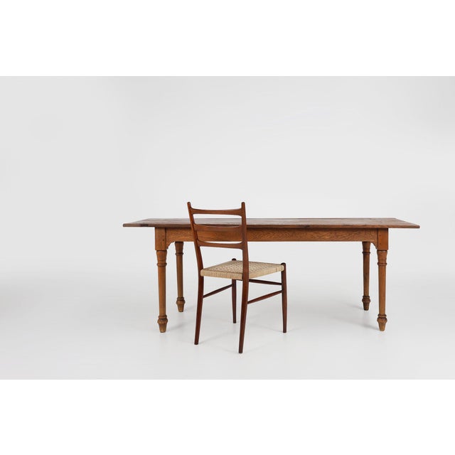 A characterful French oak dining table dating to around 1850, crafted in solid oak with the warm, tactile patina that only...