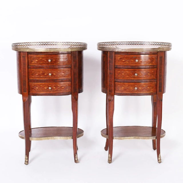 Refined pair of antique French Louis XV style stands with rouge marble tops having a brass gallery over a three drawer...
