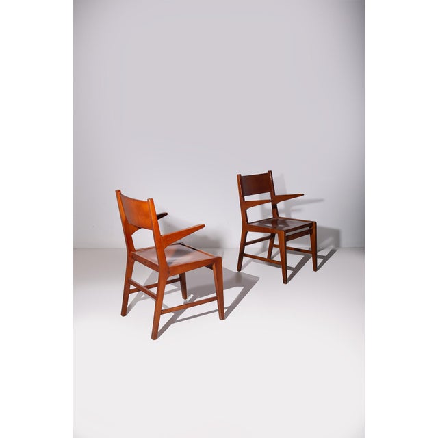 This pair of armchairs in wood represents a refined example of Italian craftsmanship from the 1950s, where the art of...