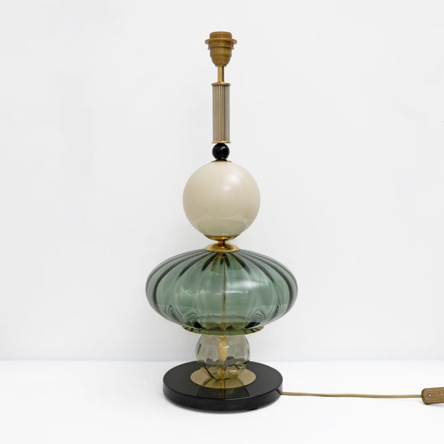 Pair of elegant table lamps crafted in Murano glass in green and white, enriched with refined brass details. The design...