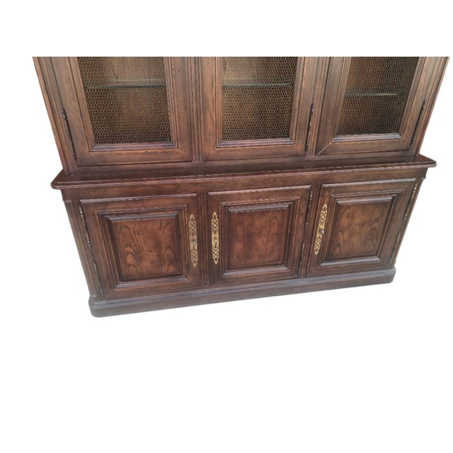 Impressive vintage display cabinet by Henredon featuring a rich wood finish, burl-wood door panels, decorative brass...