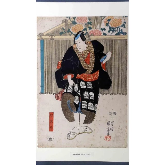 This figuration of a theater actor in a black coat on stage is the work of the Japanese artist Utagawa Kuniyoshi...