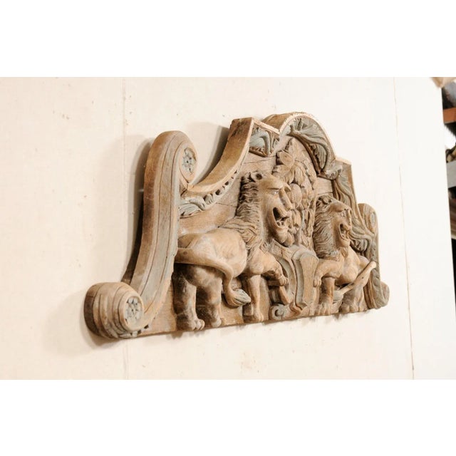 A French architectural carved wood plaque, in a lion motif, from the 19th century. This antique wall decoration from...