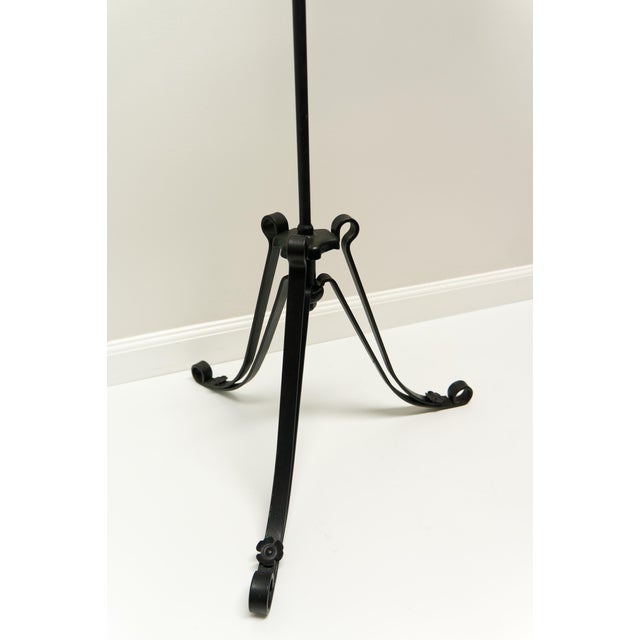 A wrought iron floor lamp with adjustable height and decorative scrollwork. Featuring a reverse painted frosted gradient...