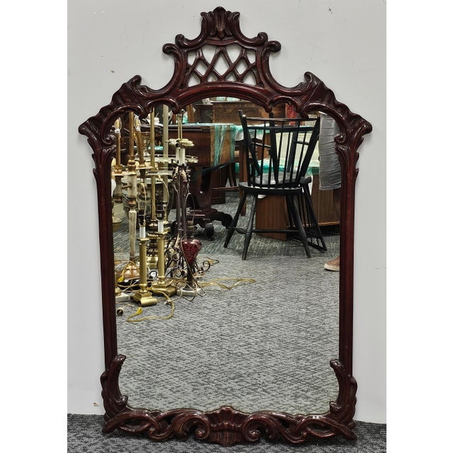 A mid Century French Style intricately Carved Mahogany Frame Wall Mirror Measures 29" in width, and 49" in height.
