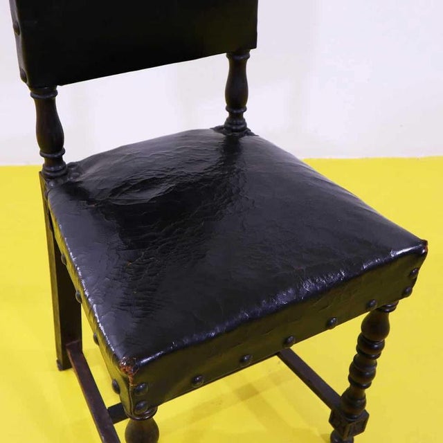 Renaissance style chair in wood and leather with studs.