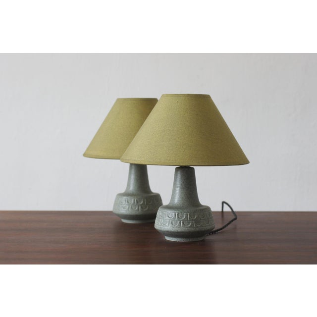 A pair of table lamps featuring compact, organically shaped ceramic bases characteristic of mid-20th-century Scandinavian...