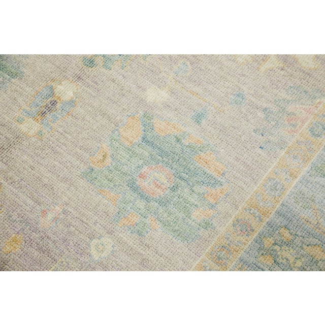 This modern Turkish Oushak rug is a stunning piece of art that has been handwoven using traditional techniques by skilled...