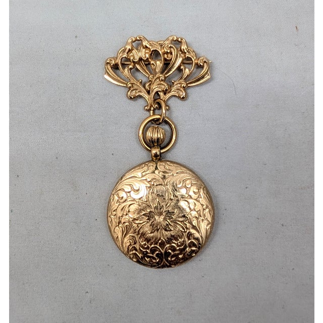 Victorian style goldtone pocket watch style pendant with floral motif brooch with security clasp. Drop doesn't open, it's...
