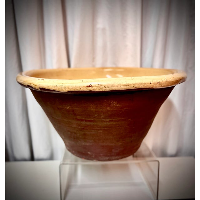 This antique tian bowl features the traditional terracotta base with a rich ochre (yellow) glaze interior and eggplant...