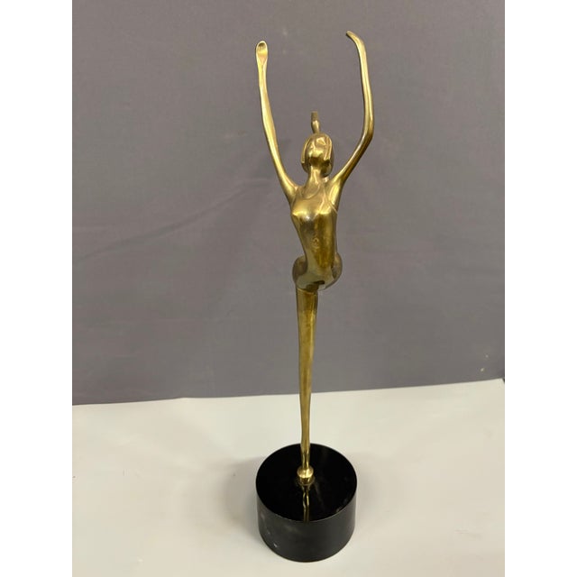 Stylized brass dancer, black lacquered wooden base, set in very good condition circa 1980
