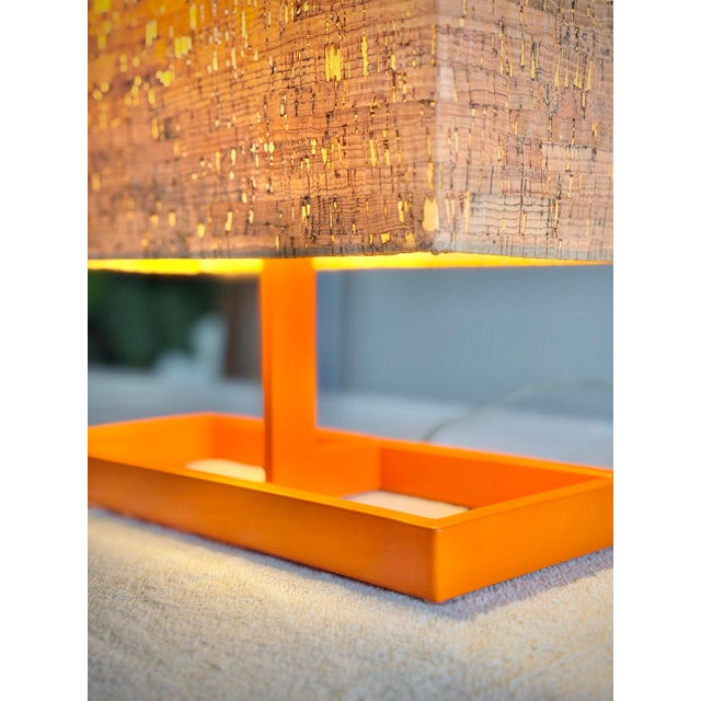 A highly sculptural vintage modern table lamp featuring a vivid architectural orange metal base paired with a rectangular...