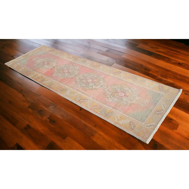 This vintage Turkish rug is a distressed runner with a bold pattern with muted colors. The style is complementary to any...