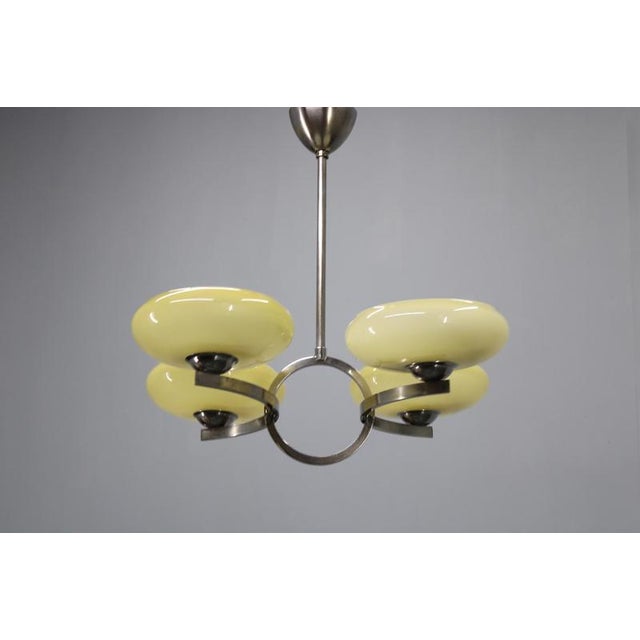 A refined art deco chandelier crafted in czechoslovakia during the 1930s, distinguished by its elegant nickel-plated metal...