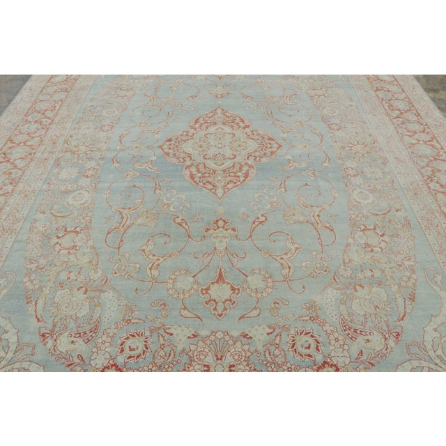 Hand-knotted in wool, this 10x14 antique rug is a refined example of Persian decorative weaving traditions. Its graceful...