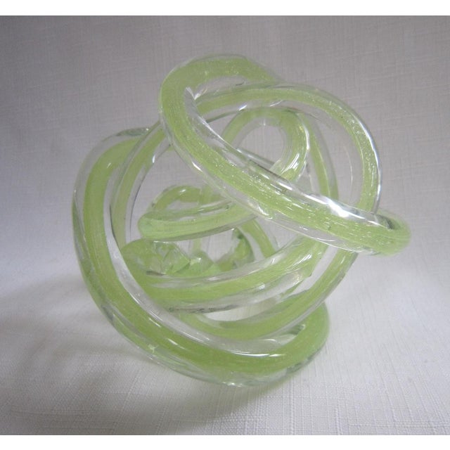 Vintage glass Love Knot sculpture in lime green. It measures 5"H x 5"D and is in excellent condition.