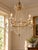 This vintage Empire style six-light chandelier is an elegant example of neoclassical revival design, combining classical...