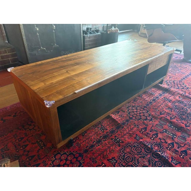 Black walnut coffee table with metal legs and single drawer. Ample under table storage on both sides. Top would benefit...