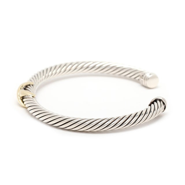 Circumference: 6.75 in. with 1 in opening Width: 5 mm Weight: 17.2 dwts. / 26.7 grams Stamps: "925 585 DY" *single X cuff...