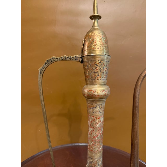 Elevate your space with this striking vintage solid brass Aftabeh (Aftabe) ewer, standing an impressive 23 inches tall....