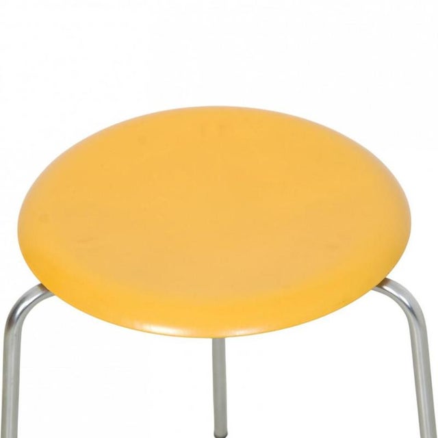 Arne Jacobsen yellow dot chair with a yellow lacquered seat and steel legs. The stool is from around the 1970s and appears...