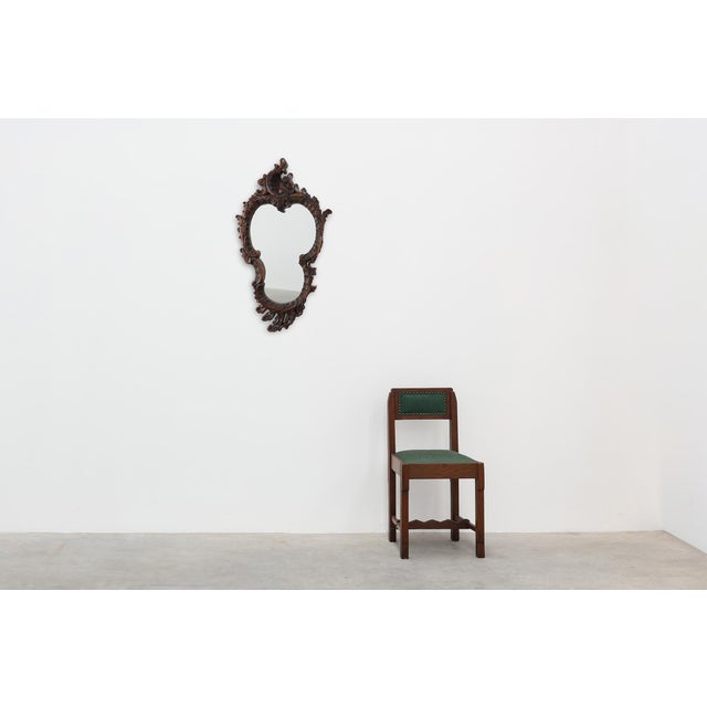 A richly carved Italian Rococo Revival mirror distinguished by its elegant cartouche-shaped mirror plate and sculptural...