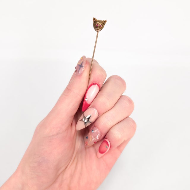 A fine vintage gold & spinel stickpin. In 14 karat yellow gold (with a 10k pinstem). In the form of a bear's head with red...